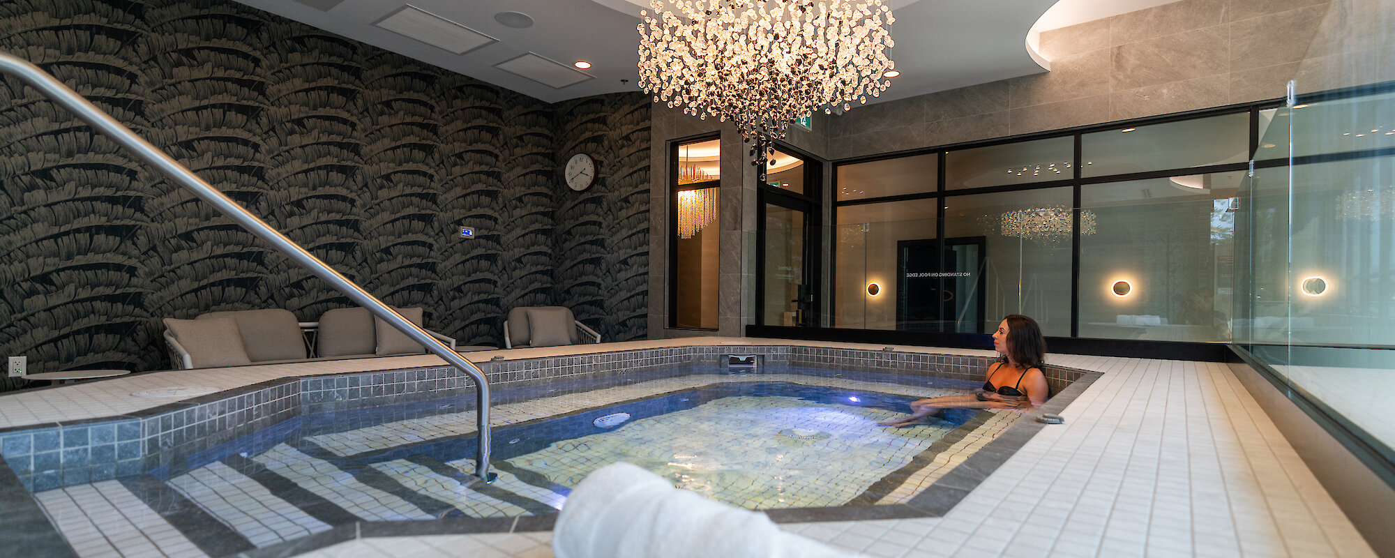 mineral pool and experience showers with a beautiful chandelier over the pool and loungers to the side